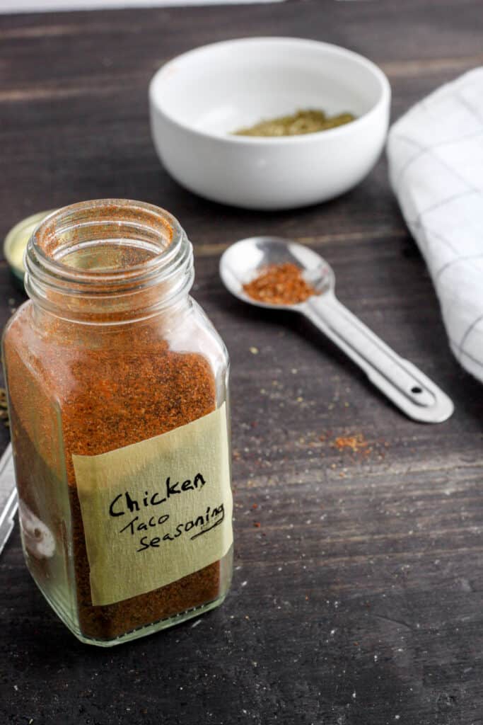 A glass spice jar with chicken taco seasoning.