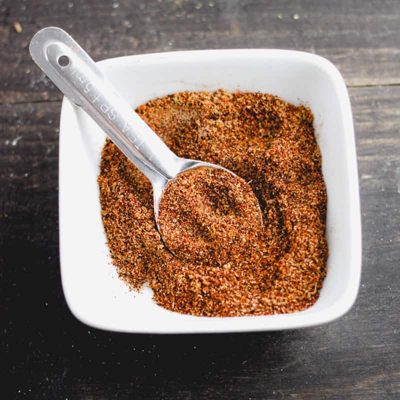 A bowl of chicken taco seasoning with a measuring spoon inside.