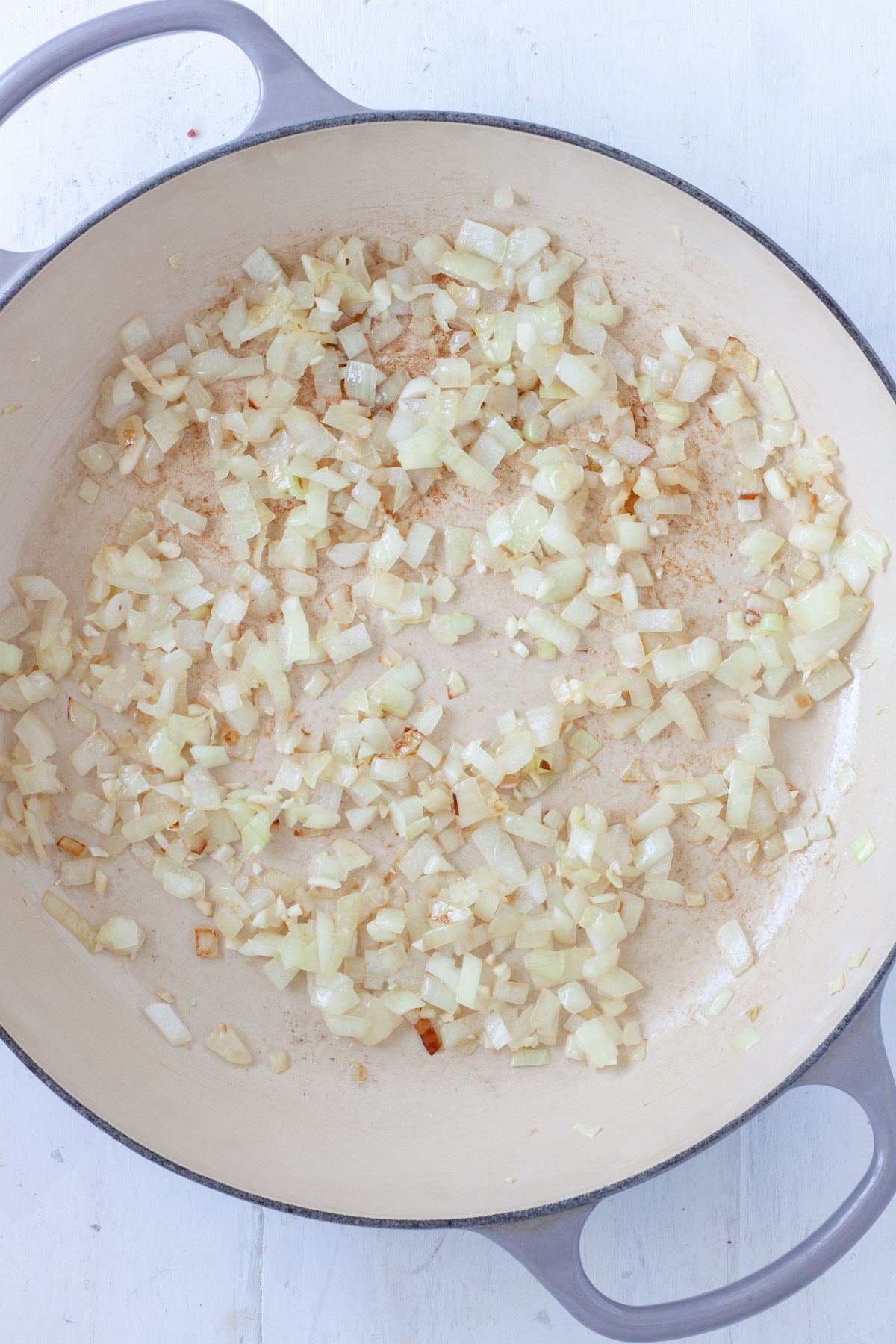 Onions cooking in a large skillet.