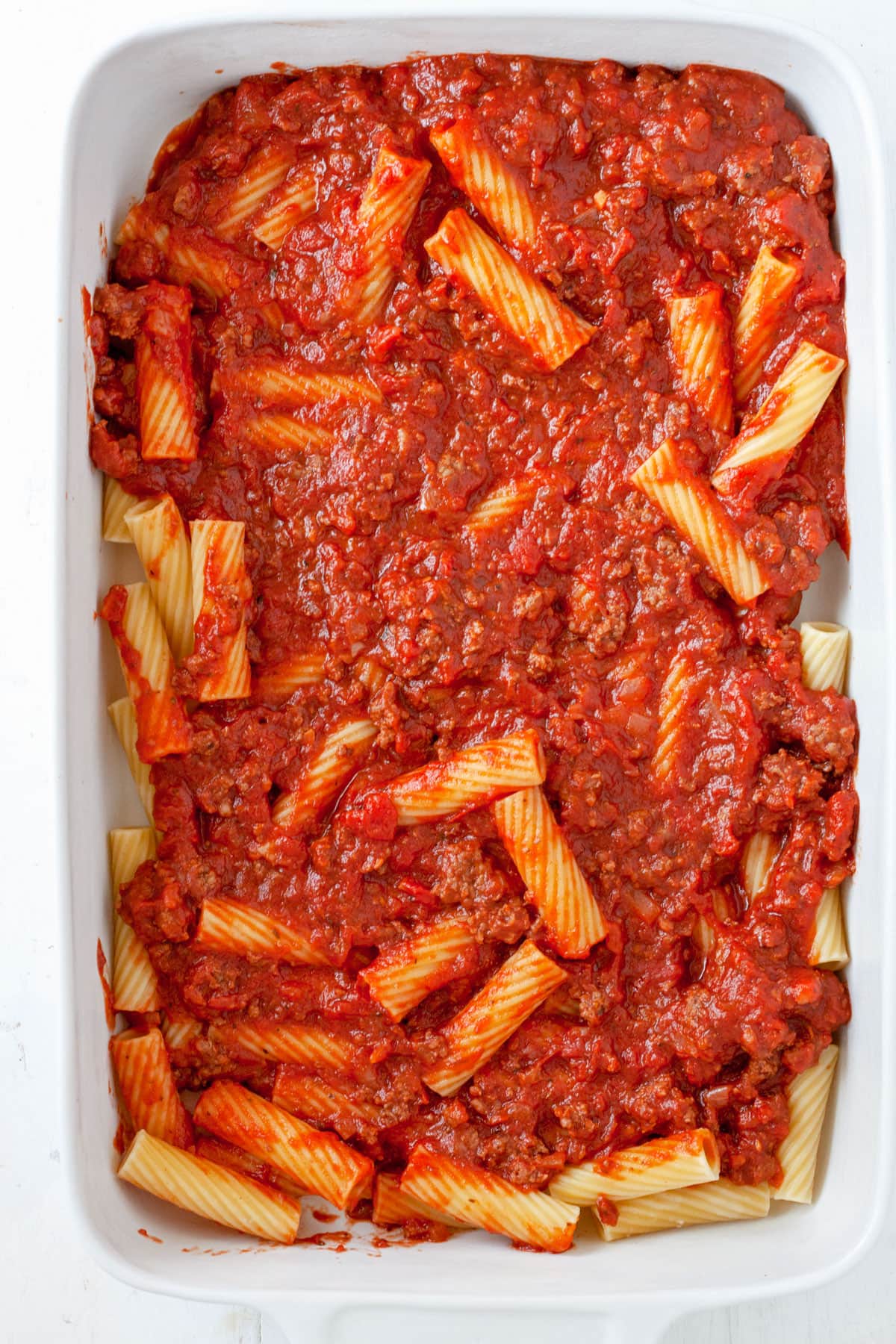 Rigatoni al Forno assembling in a baking dish.