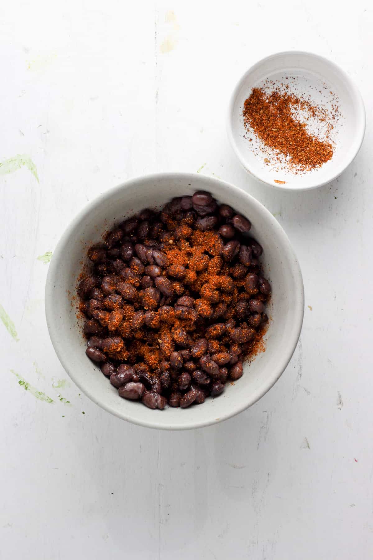 A small bowl with black beans topped with taco seasoning.