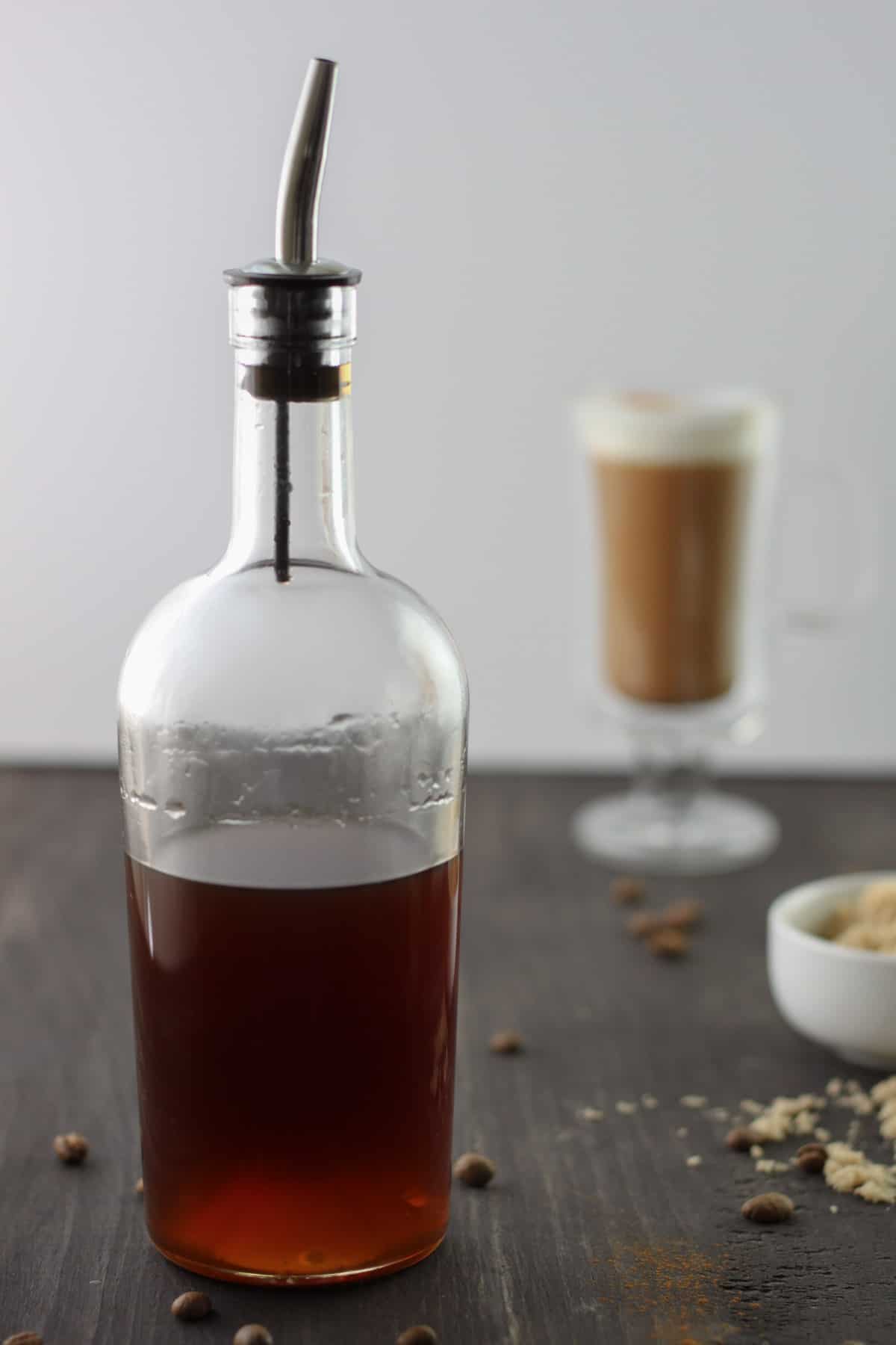 Brown sugar simple syrup in a glass bottle on a dark brown table.