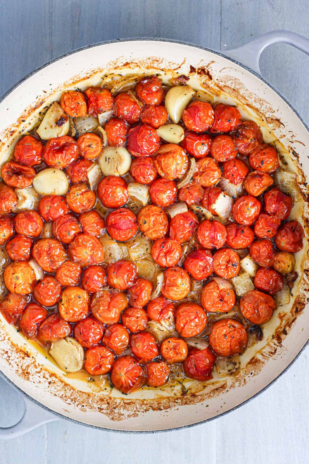 Roasted cherry tomatoes, garlic and onions in a braiser pan.