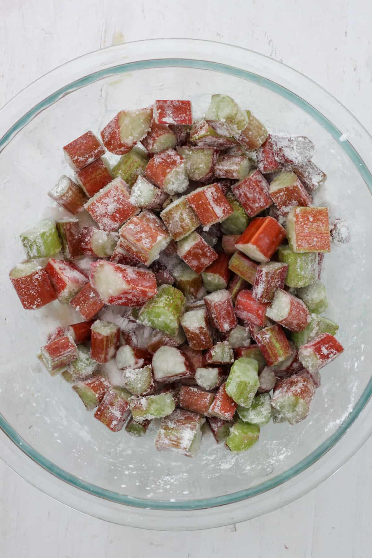 A bowl of chopped rhubarb tossed with sugar and cornstarch.