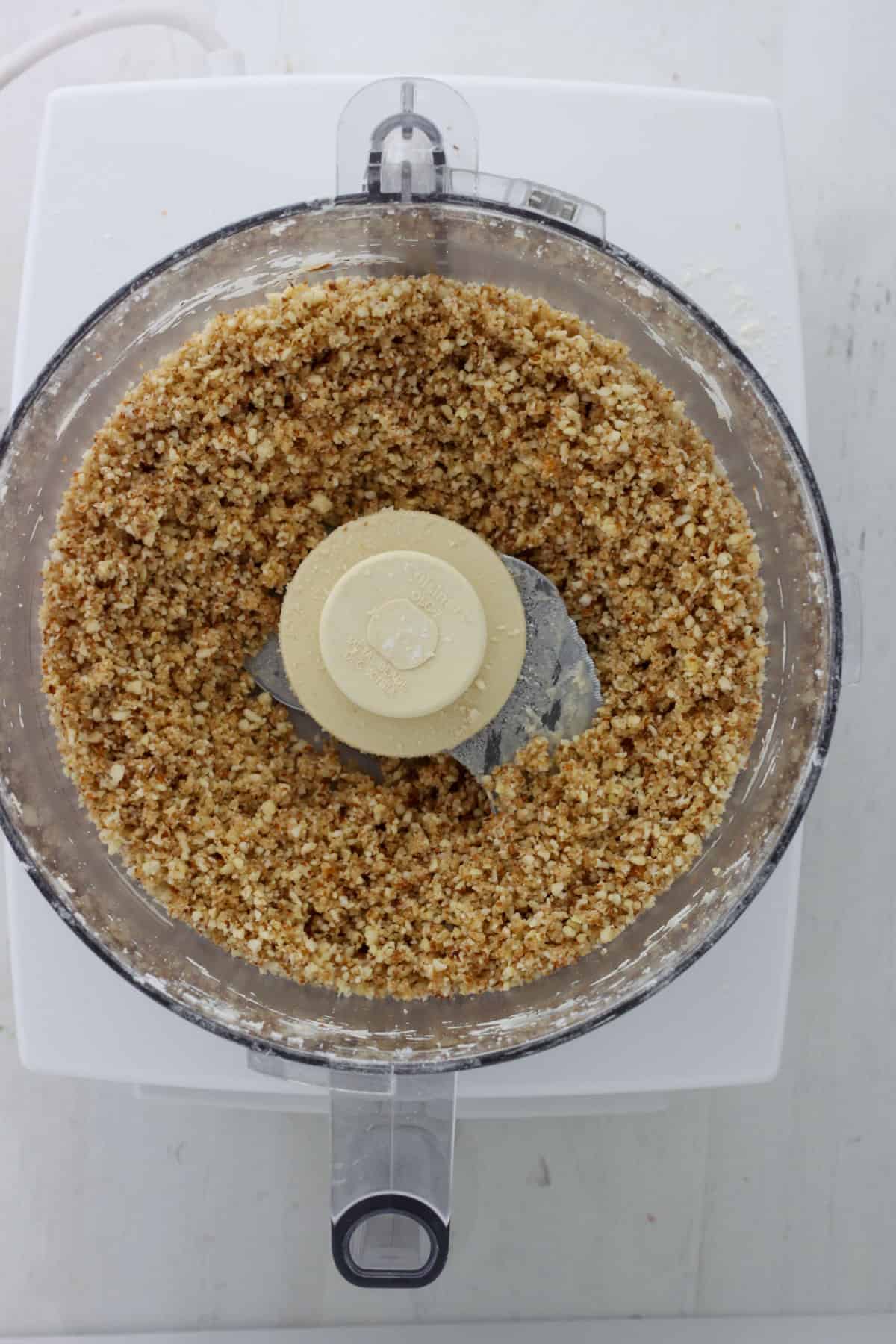 A food processor with ground almond and flour inside.