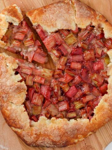 Rhubarb galette on a pizza peel with a slice cut away.