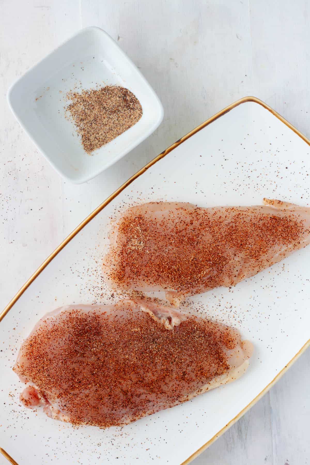 Chicken breasts sprinkled with a spice rub.