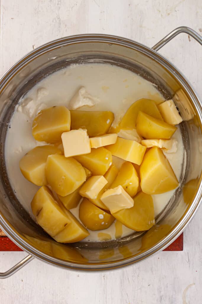 Potatoes, sour cream, butter and milk in the bottom of a large pot.