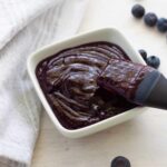 Blueberry BBQ Sauce in a small bowl with a pastry brush inside.