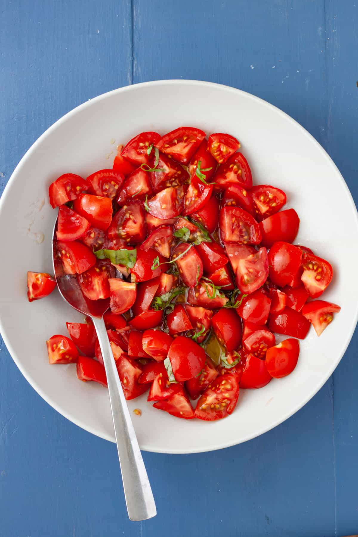 A bowl of chopped tomatoes, basil, olive oil and balsamic vinegar.