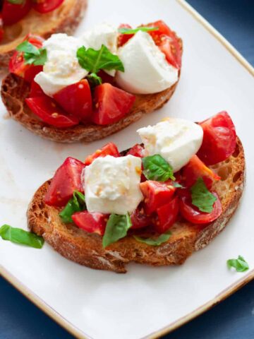 Burrata Bruschetta on a small white plate.