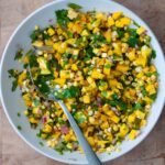 Mango and Corn Salsa in a medium bowl with a spoon.