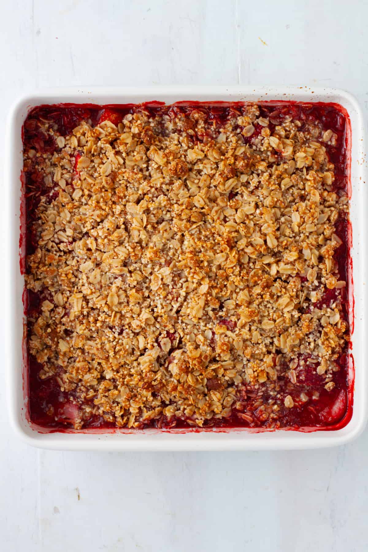 A cooked strawberry crumble in a baking dish.
