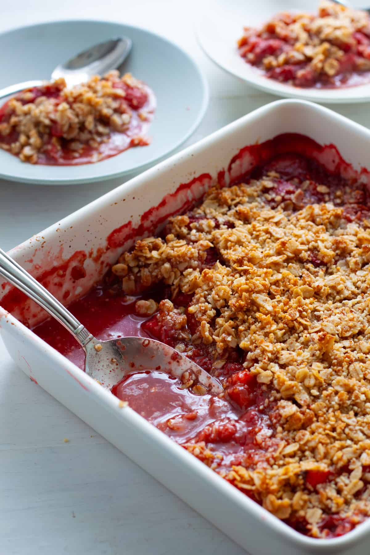 Strawberry crumble with a scoop taken out and put on a small plate.