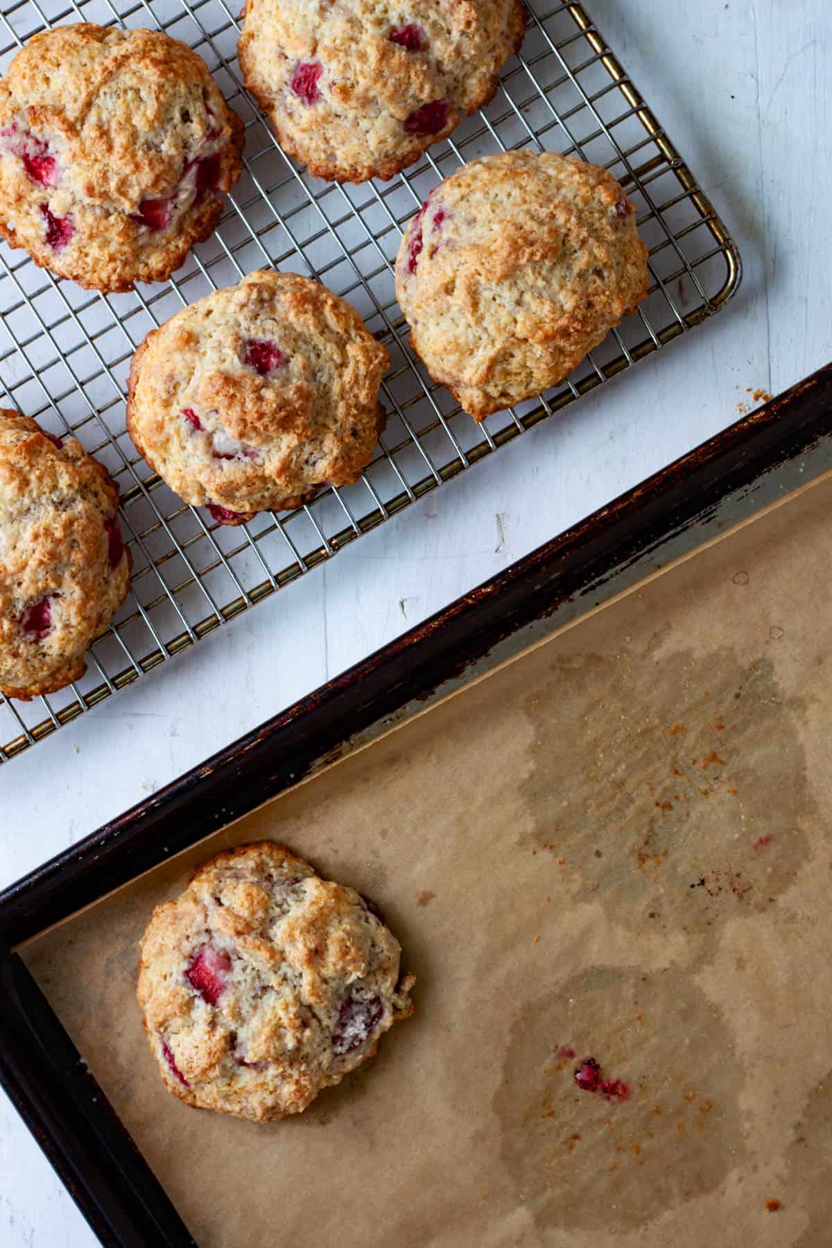 Strawberry biscuits getting transferred to a wire rack to cool.