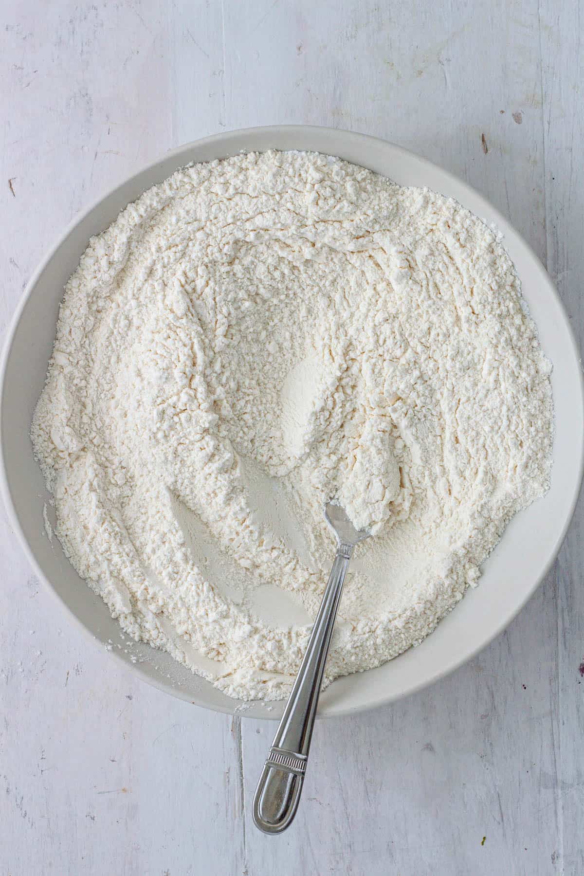 Flour, baking powder, baking soda, salt and sugar in a mixing bowl.