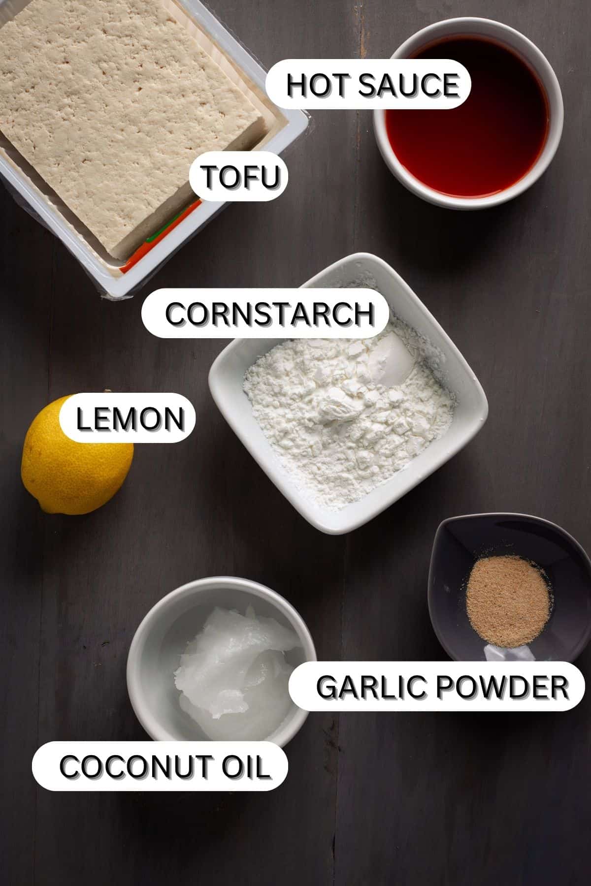 Ingredients for crispy buffalo tofu on a dark table.