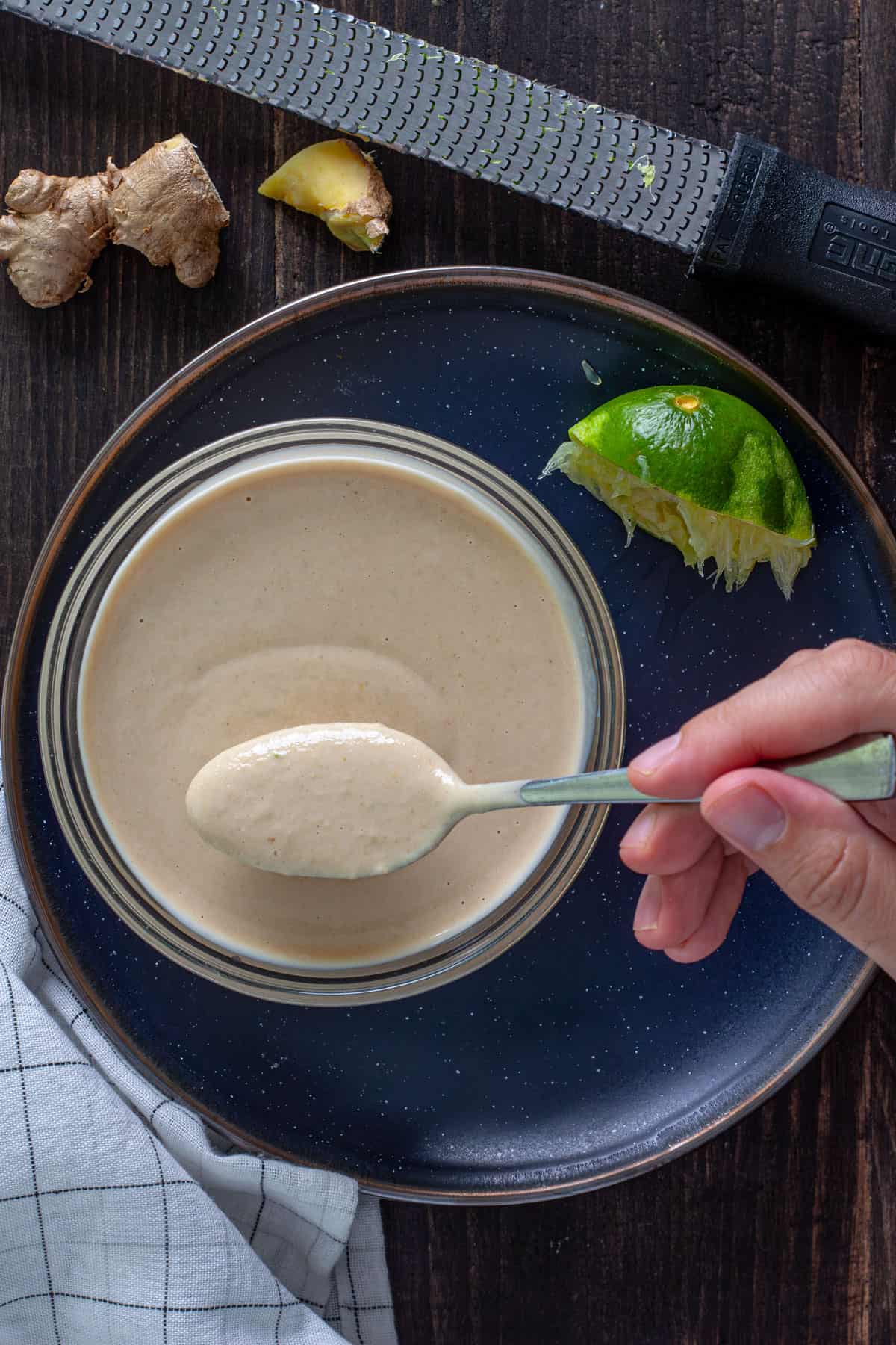 Miso tahini dressing in a small bowl with a spoon taking a small spoonful out.