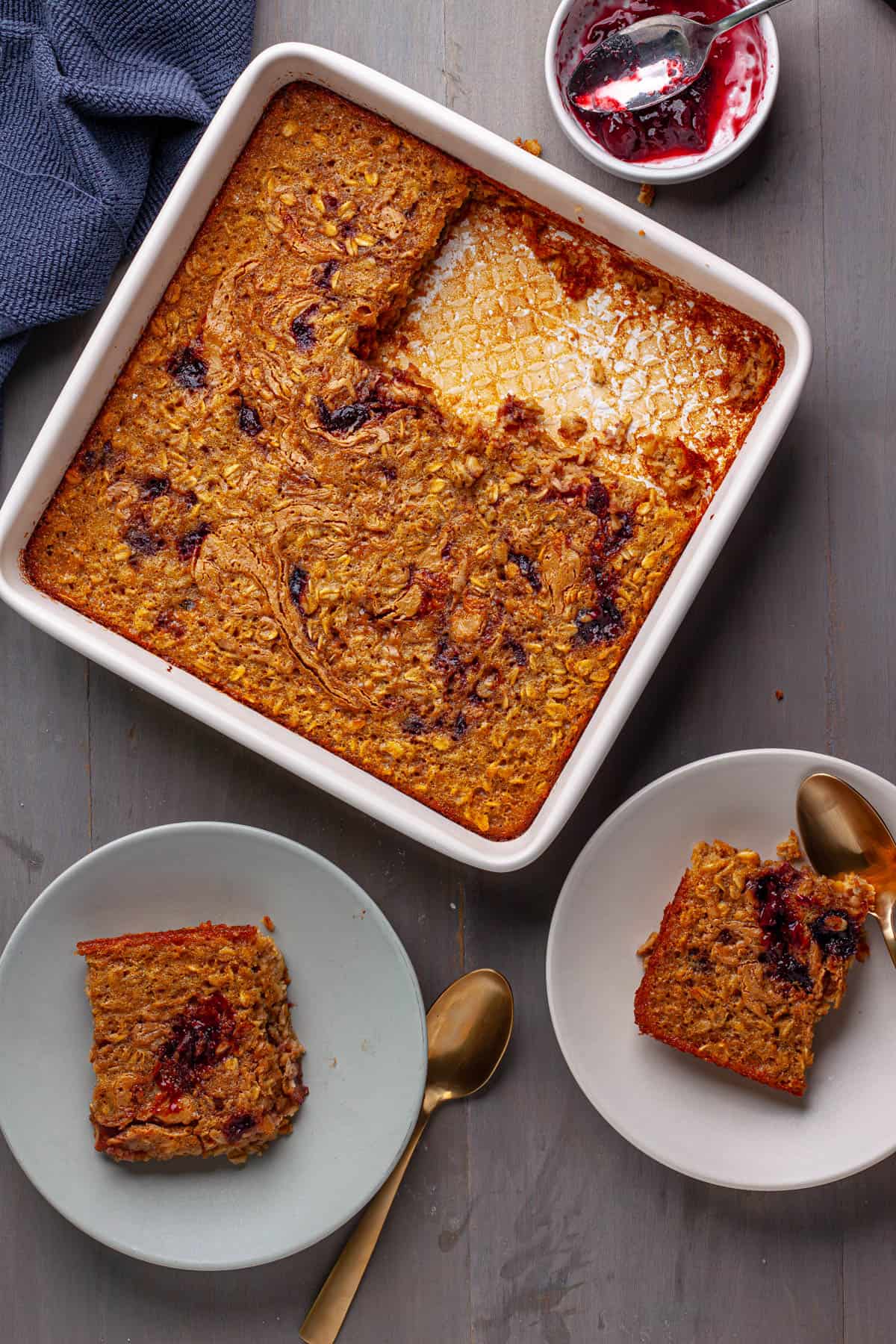 A cooked peanut butter and jam baked oatmeal in a square baking dish.