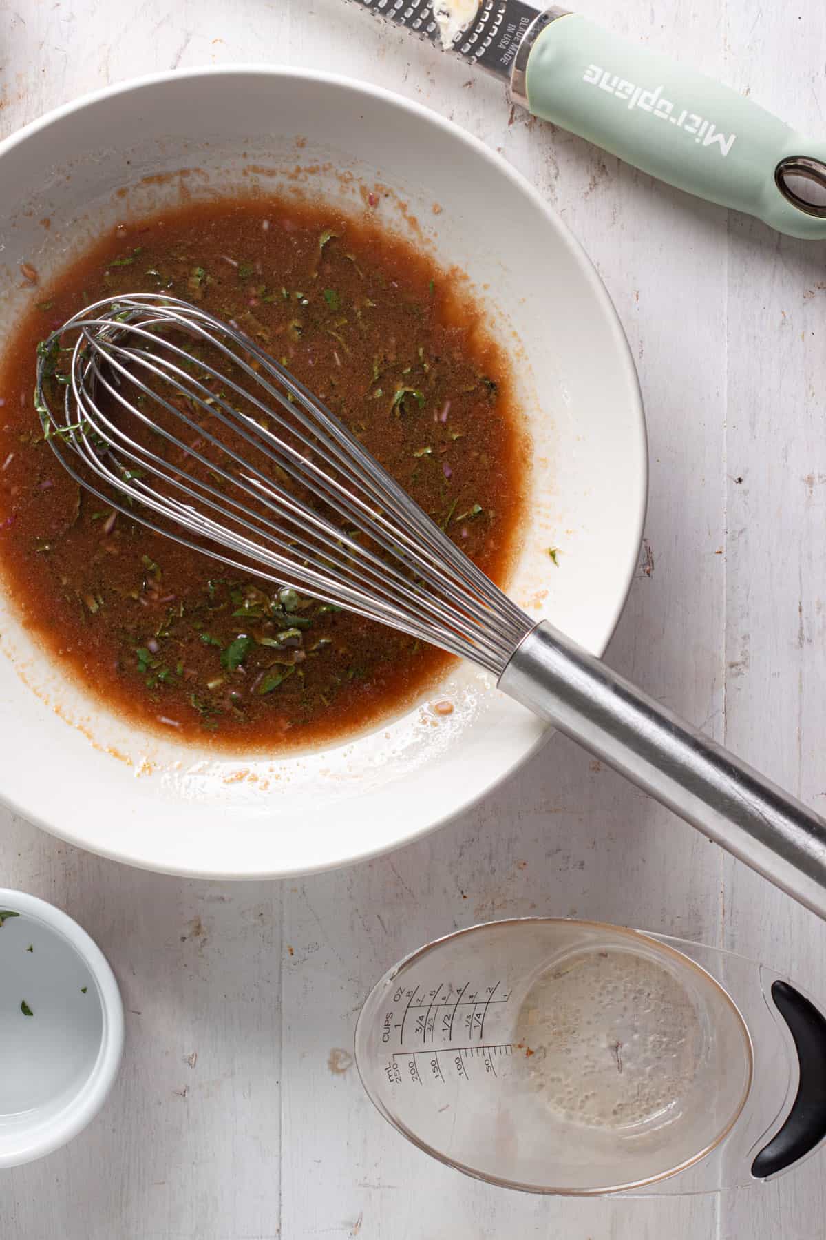 Oil whisked into a basic balsamic vinaigrette in a medium bowl.