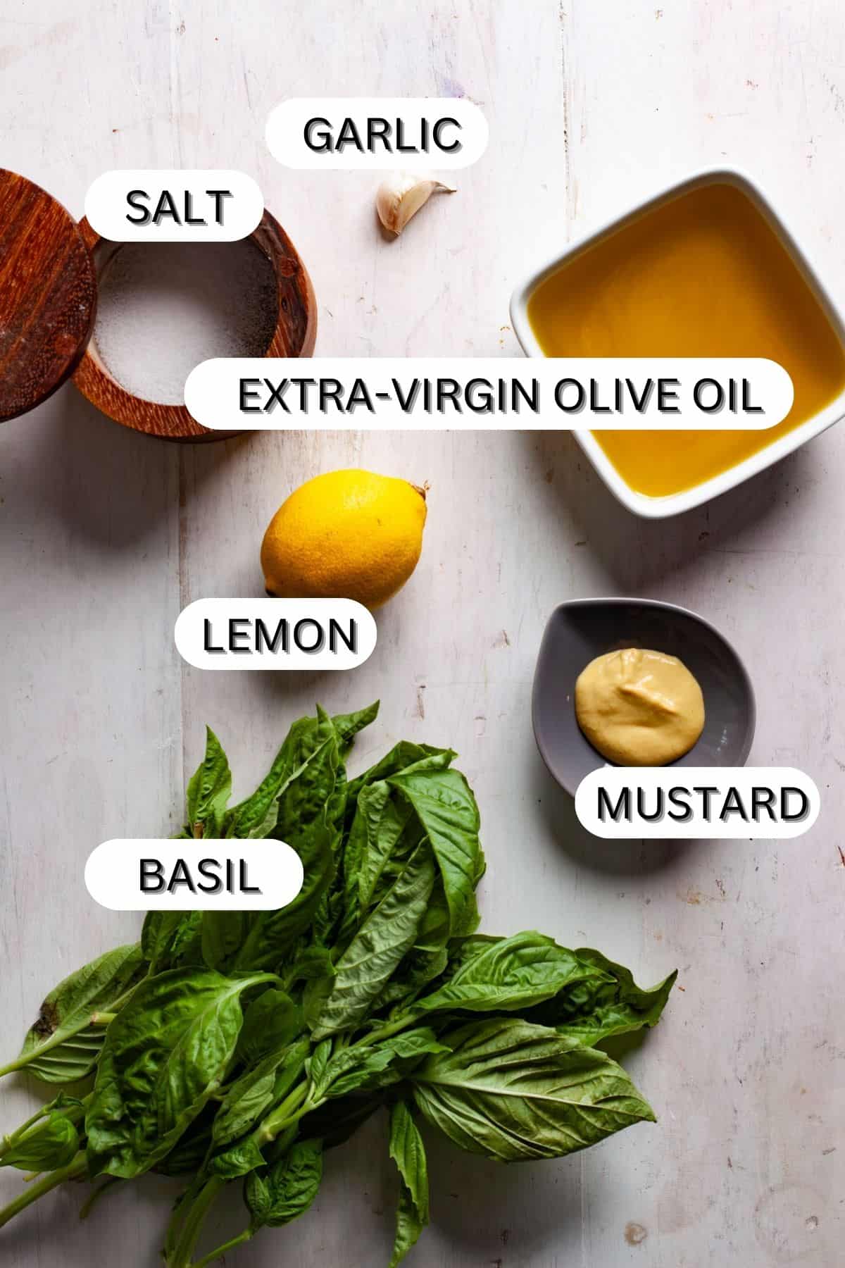Ingredients for basil vinaigrette on a white table.