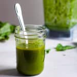 Basil vinaigrette in a mason jar with a spoon inside.