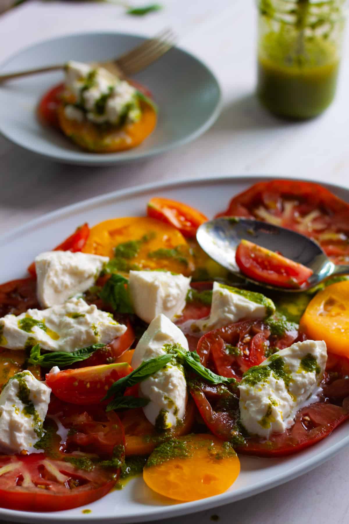 Burrata CAprese Salad with Basil Vinaigrette on a serving platter.