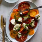 Burrata CAprese Salad with Basil Vinaigrette on a serving platter.