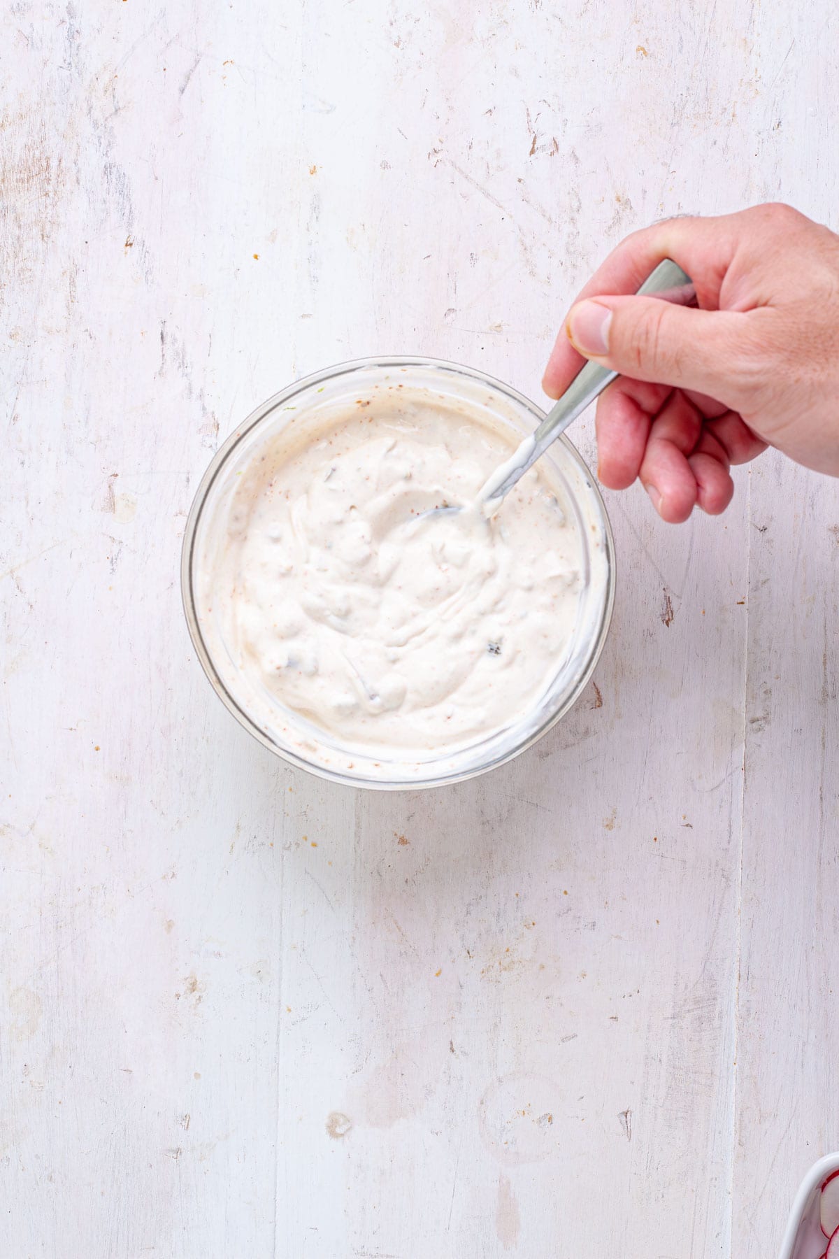 A sour cream and jalapeno sauce for chili lime shrimp tacos in a small bowl.