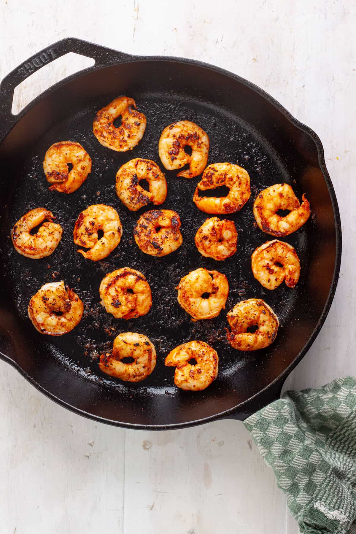 Chili lime shrimp searing in a large cast iron skillet.