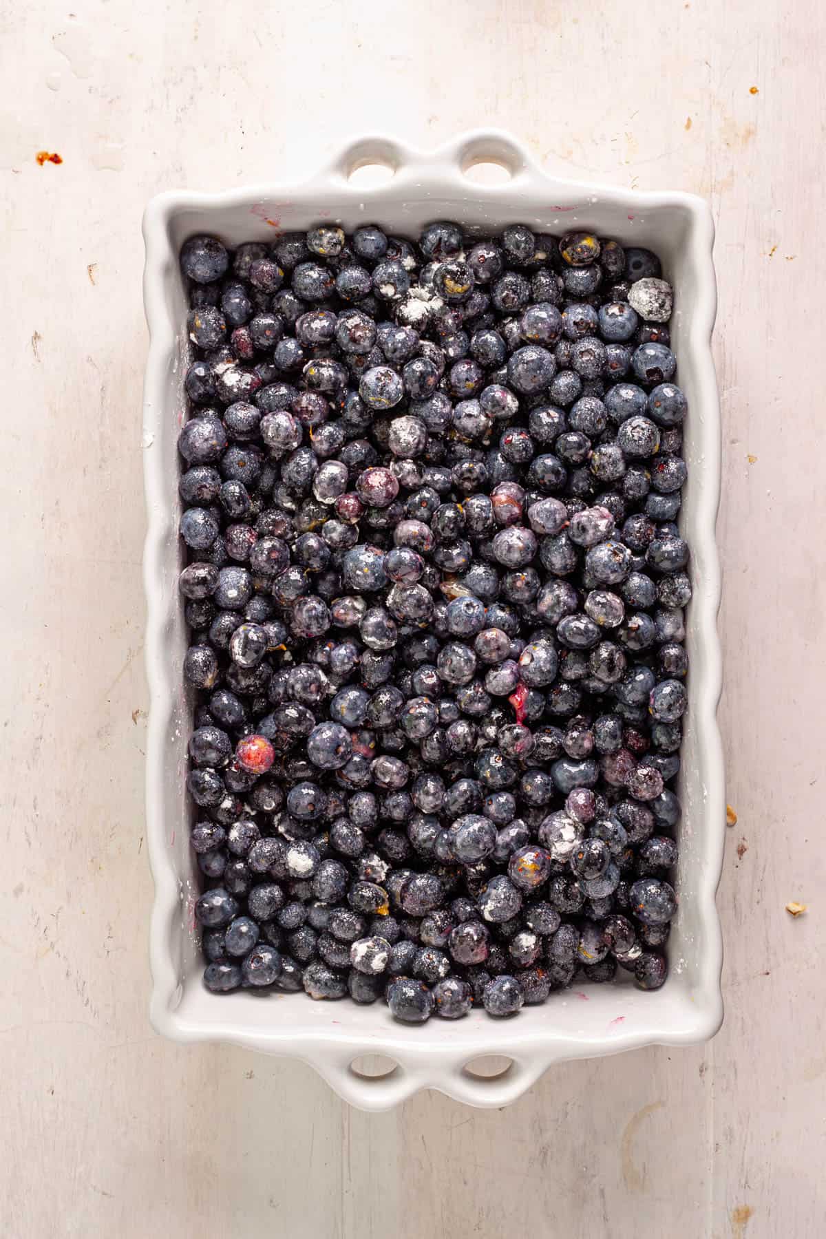 Blueberries, cornstarch and sugar in a white baking dish.