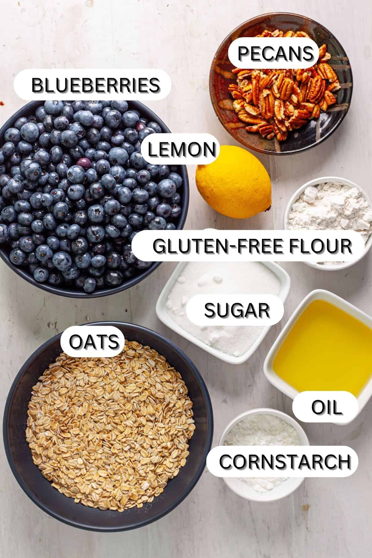 Ingredients for a vegan blueberry crisp on a white table.