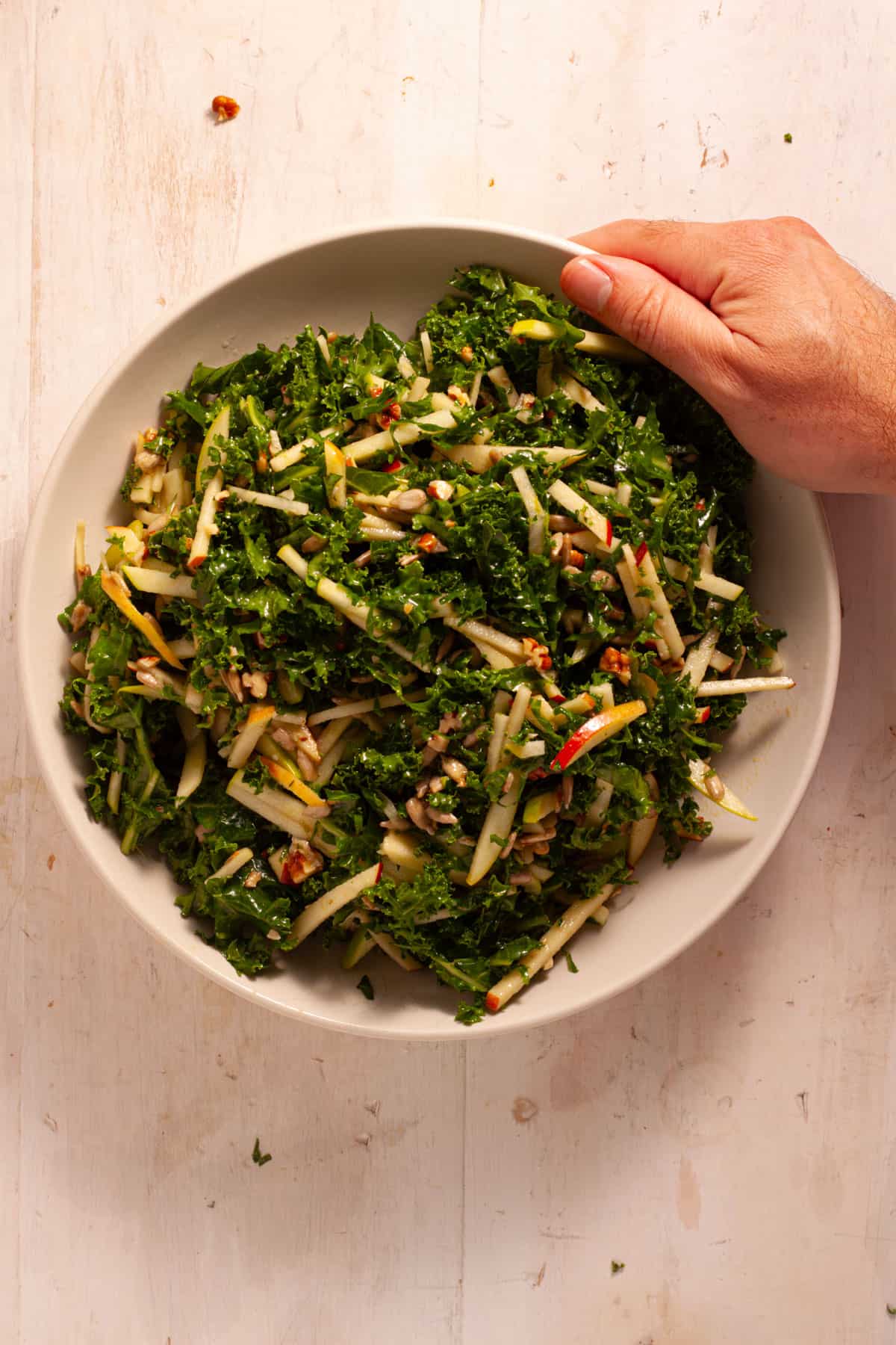 Kale and Apple Slaw topped with maple Dijon dressing in a serving bowl.