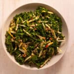 Kale and Apple Slaw topped with maple Dijon dressing in a serving bowl.