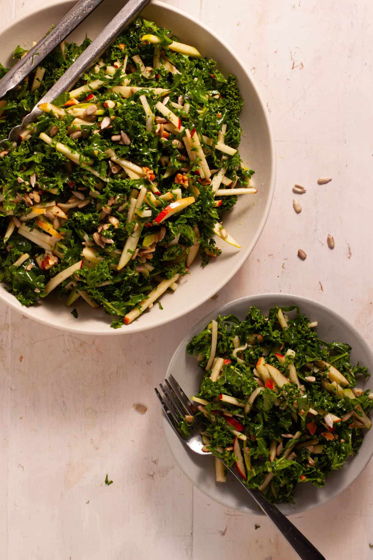 Kale and apple slaw on a small serving plate and in a serving bowl.