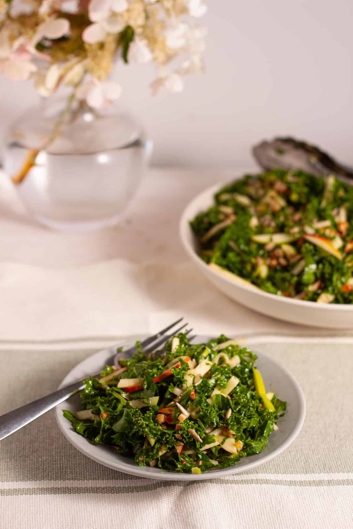 Kale and Apple Slaw in a small plate with a bigger bowl in the background.
