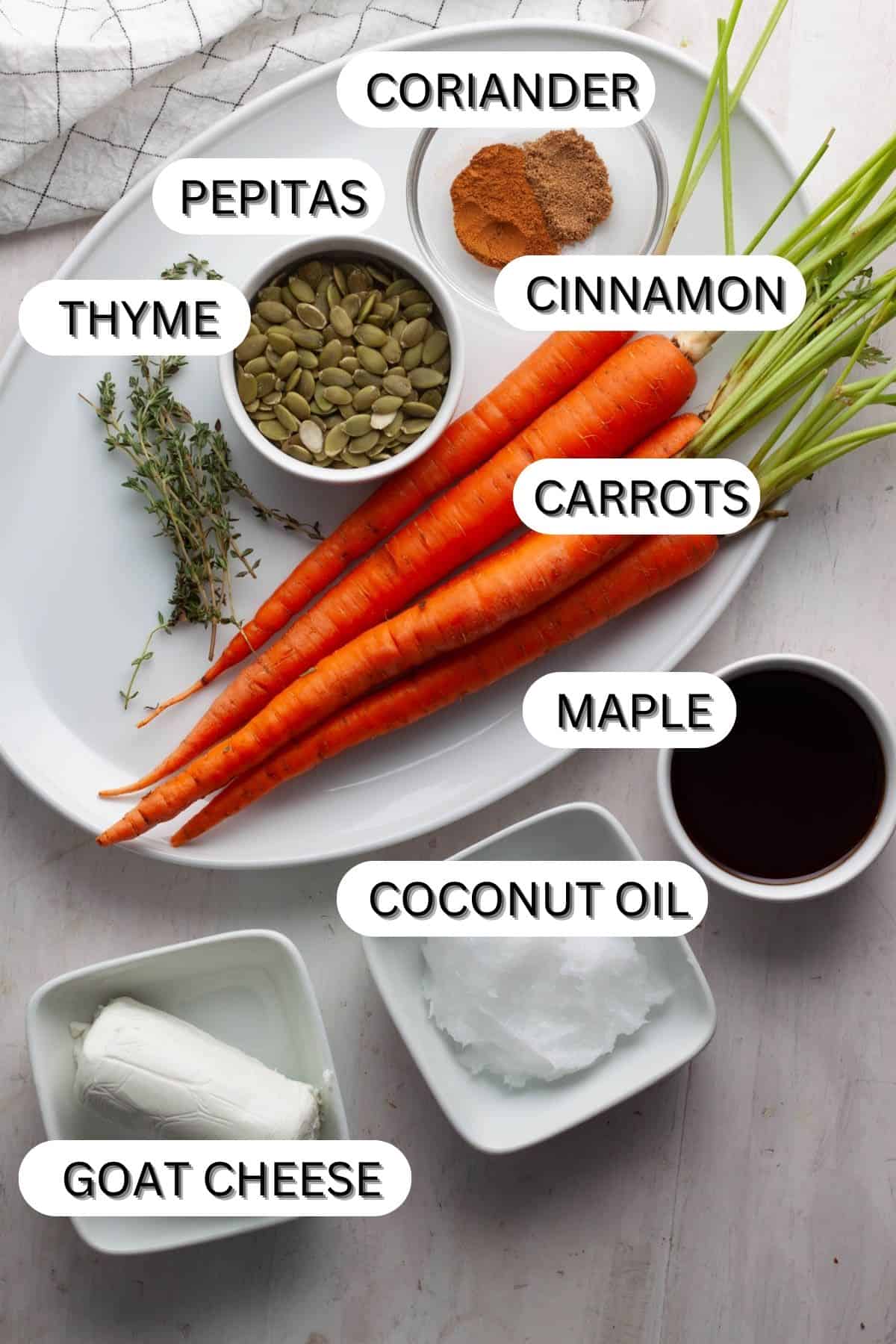 Ingredients for maple roasted carrots on a white table.