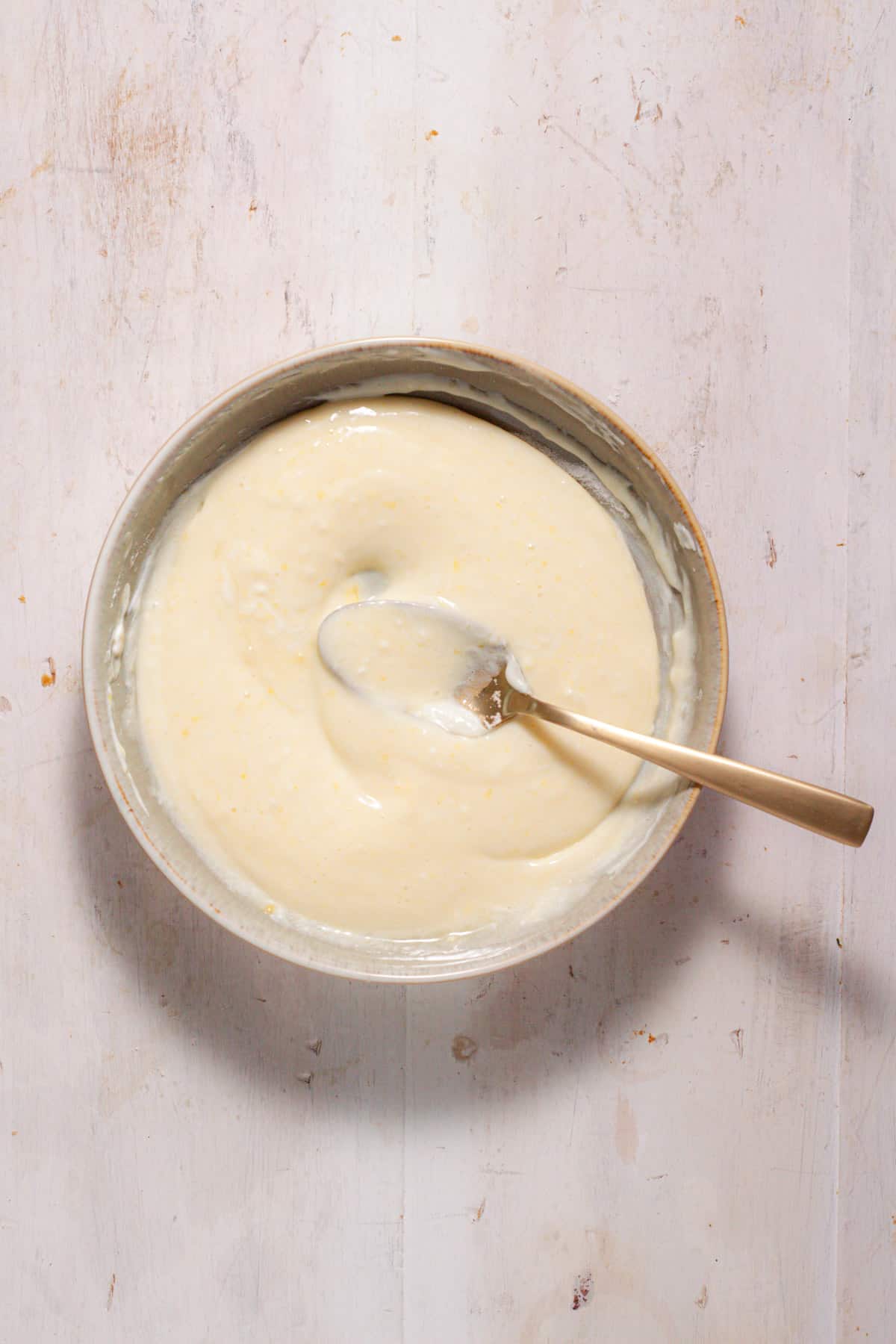 A sour cream custard for mini peach pies in a medium bowl.