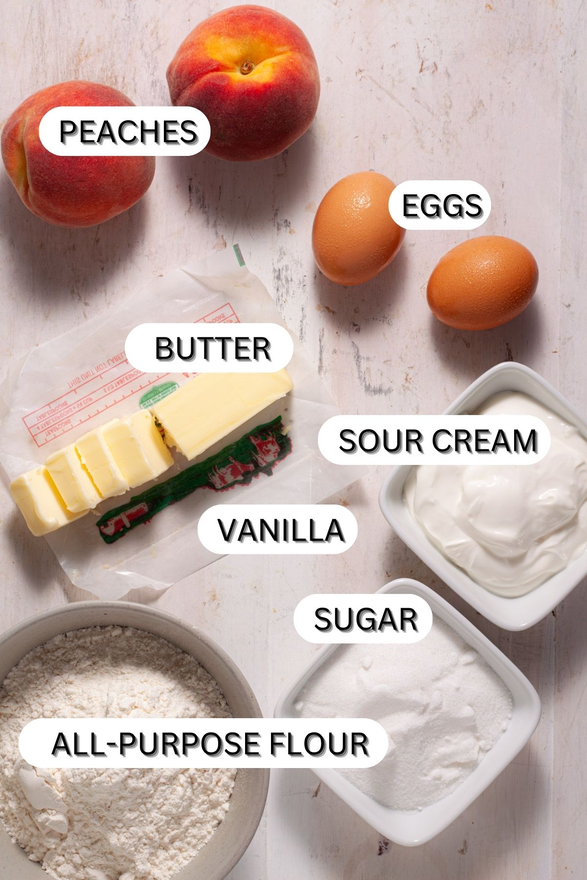 Ingredients for mini peach custard pies on a white table.