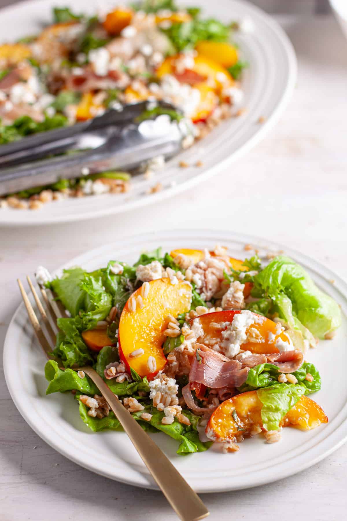 A serving of peach and goat cheese salad topped with farro.