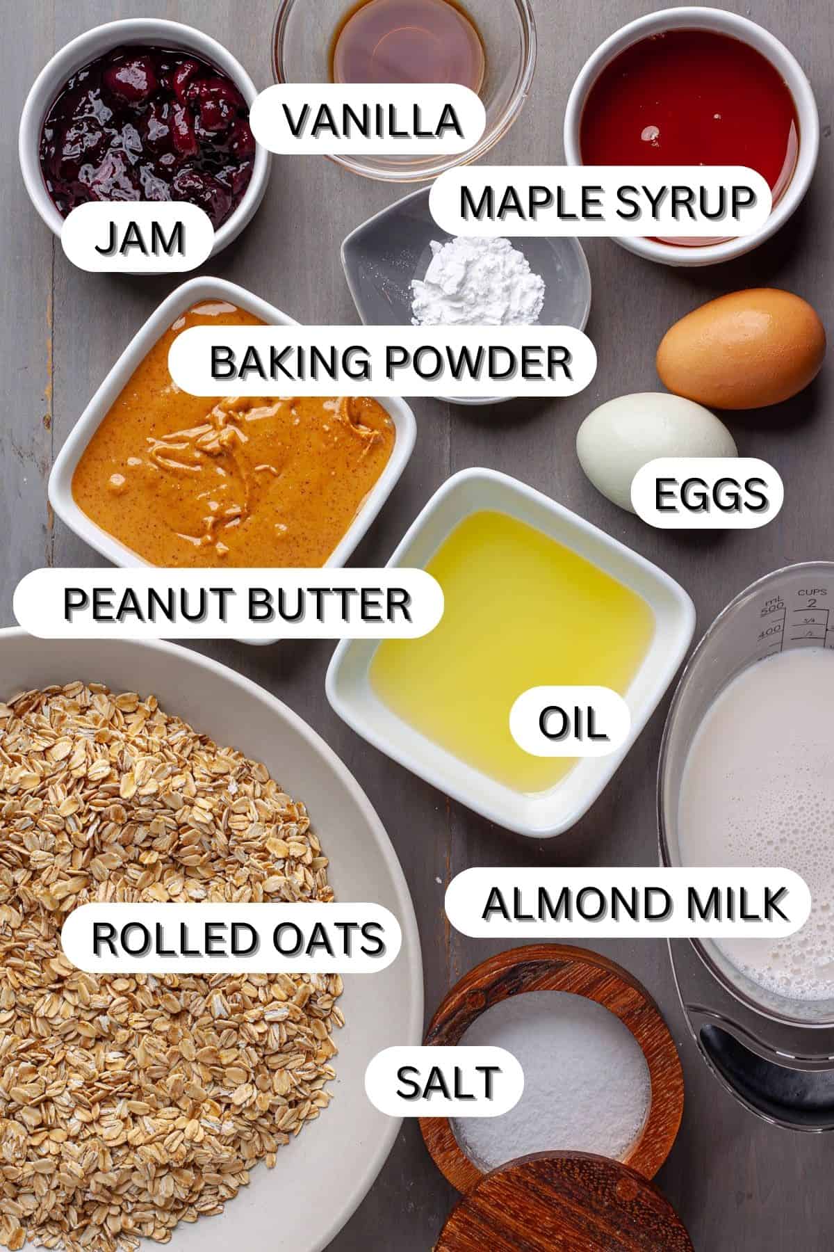 Ingredients for a peanut butter and jam baked oatmeal in a gray table.