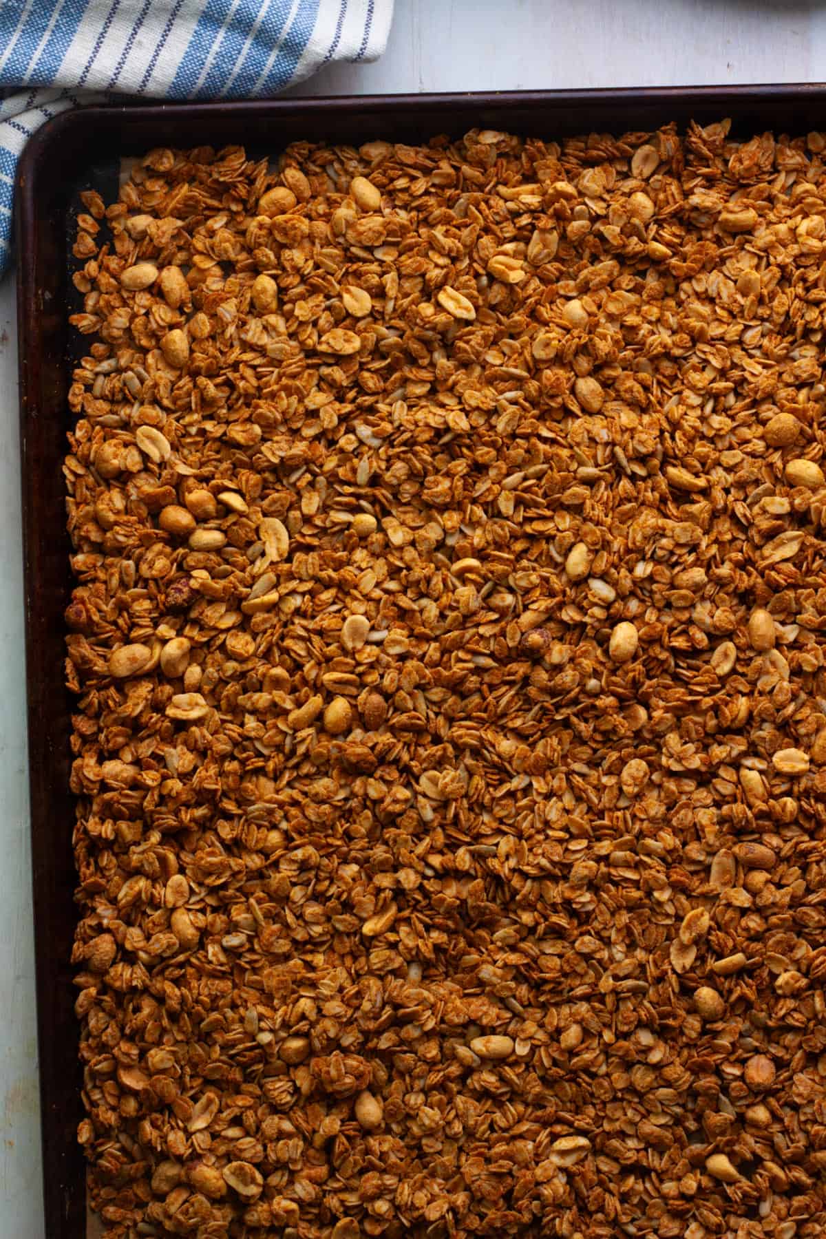 Cooked homemade peanut butter granola on a baking sheet.