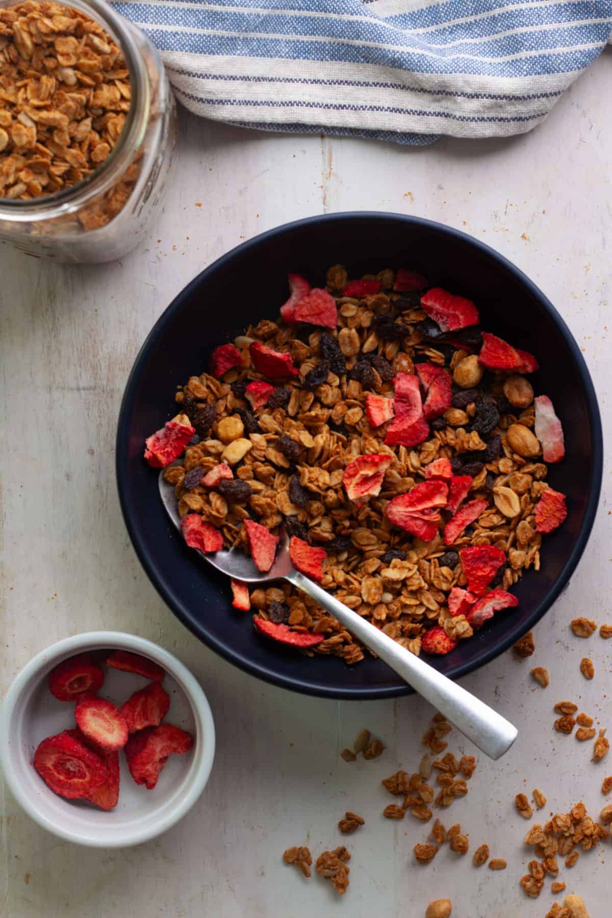 A bowl of peanut butter granola with strawberries.