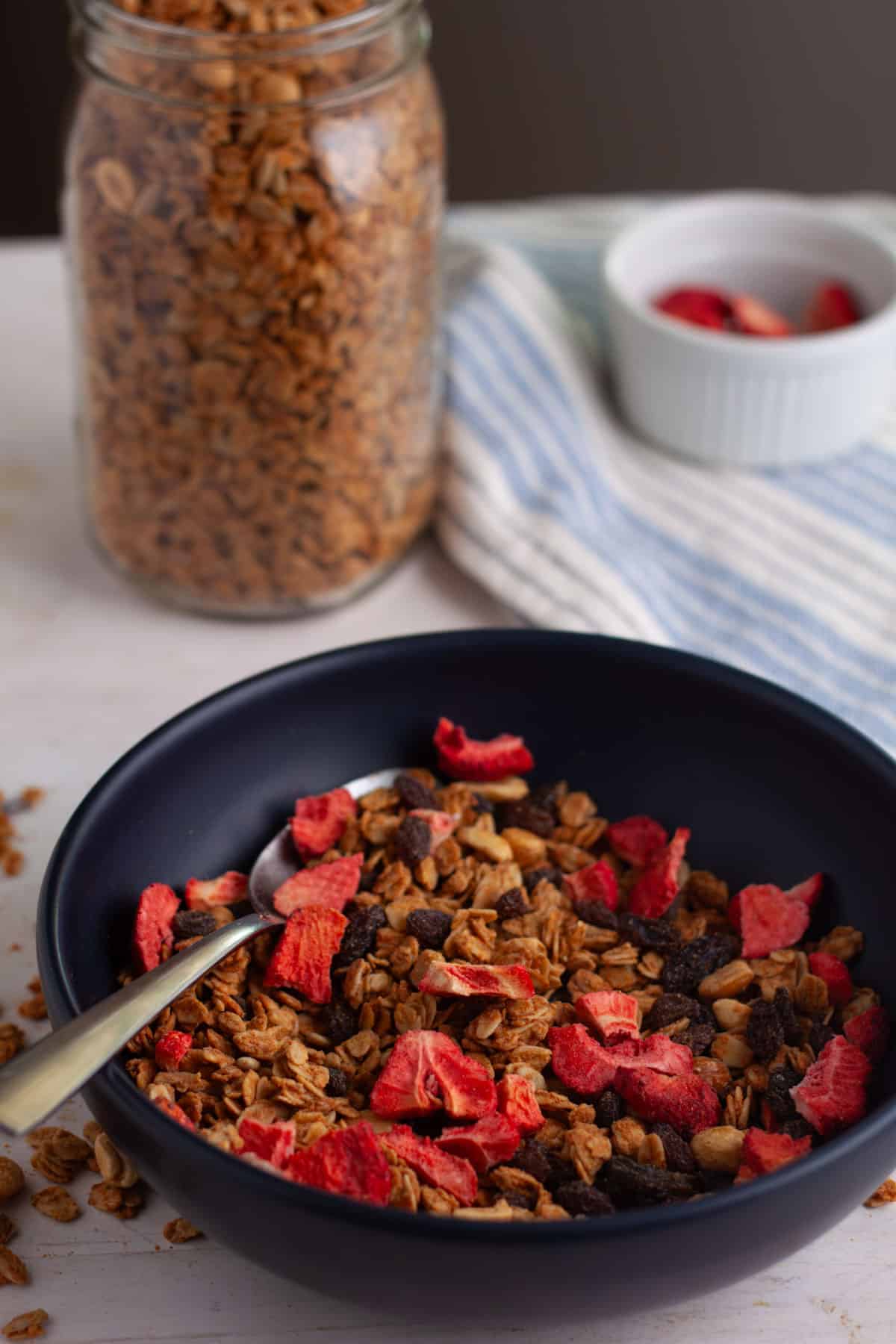 homemade peanut butter granola in a bowl with dried strawberries.