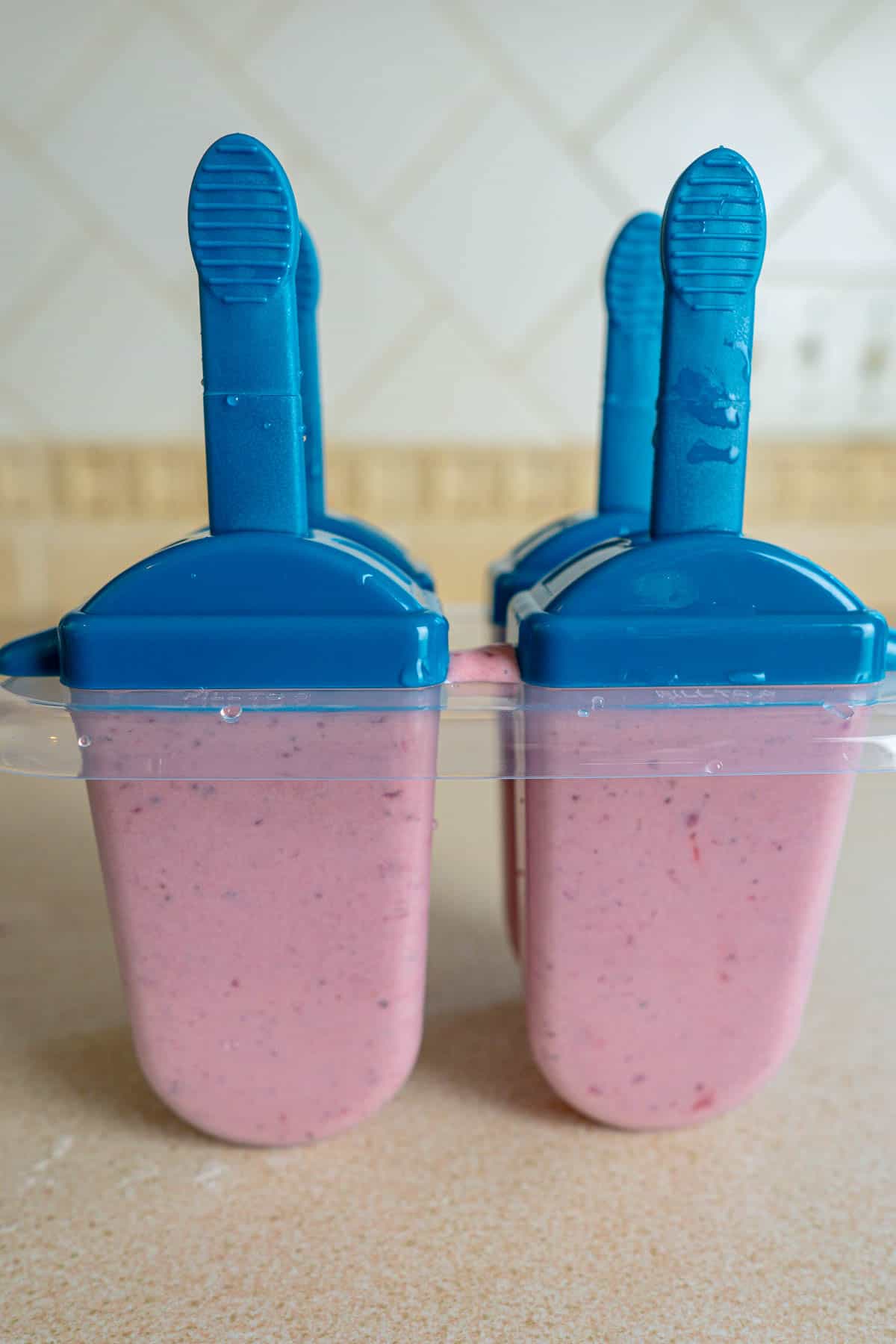 Roasted strawberry and cream popsicles in a popsicle mold waiting to freeze.