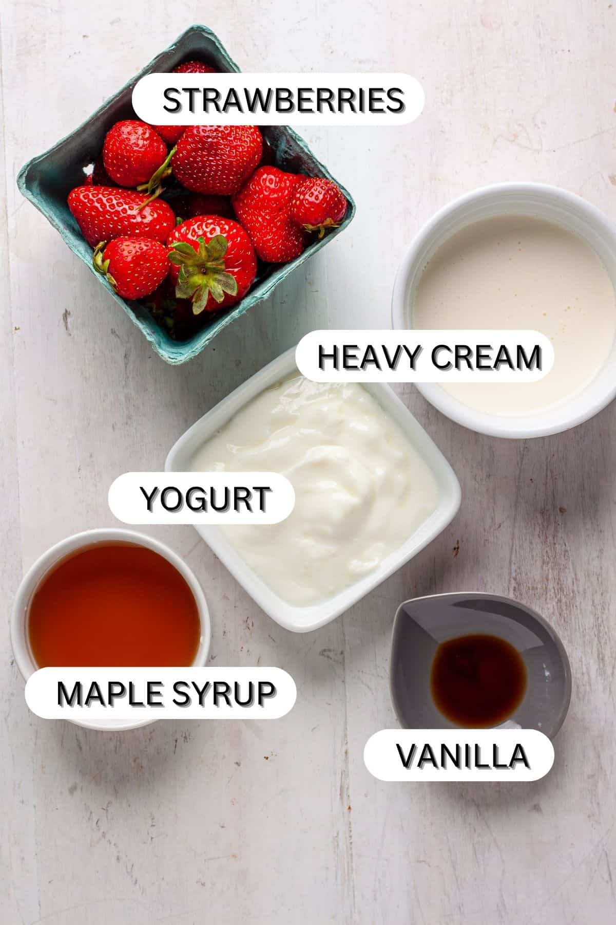 Ingredients for strawberry popsicles in a white table.