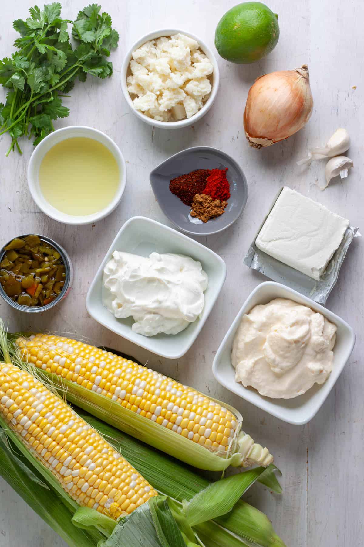 Ingredients for skillet street corn dip on a white table.