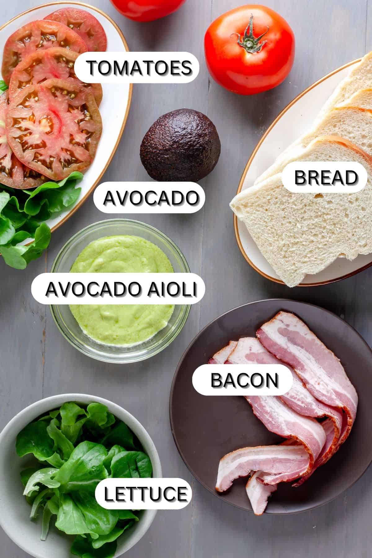 Ingredients for a avocado blt on a gray table.