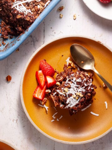 German chocolate cake baked oatmeal in a baking dish with a couple servings on small plates.