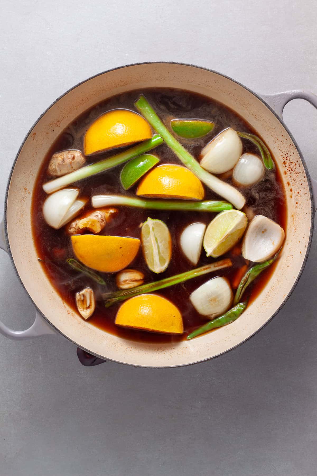 Sauce for a spicy chicken with citrus, ginger and soy getting prepared in a large skillet.